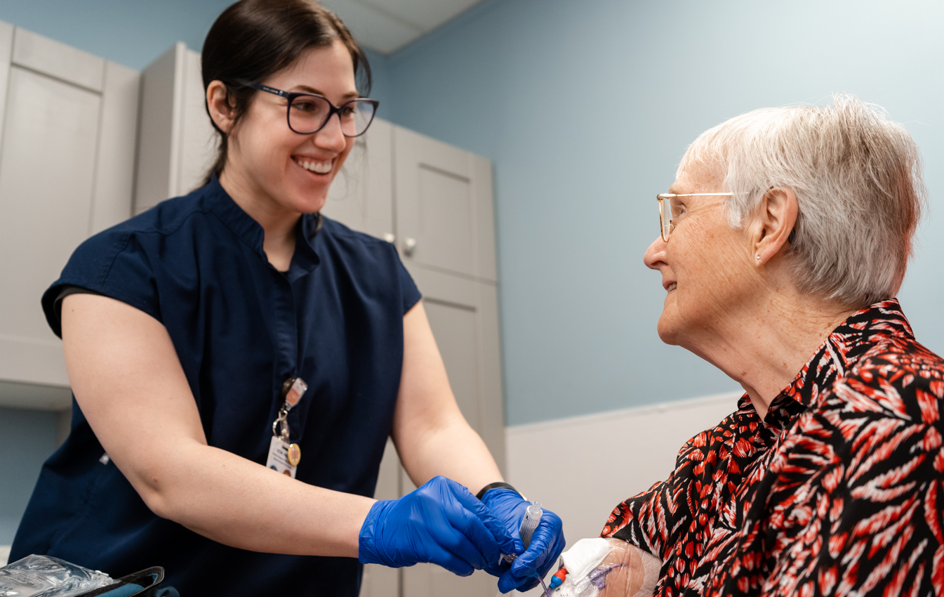 VON nurse performing a medical procedure on a client in a clinic environment.
