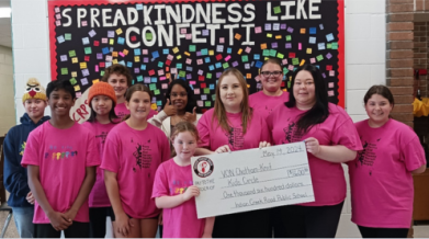 Indian Creek Road Public School student t-shirt designers and staff present a cheque for $1,600 to Kids’ Circle staff.