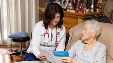 A female VON nurse reviewing information in a booklet with a senior female. Written below is "Photo credit: the Sobey Foundation